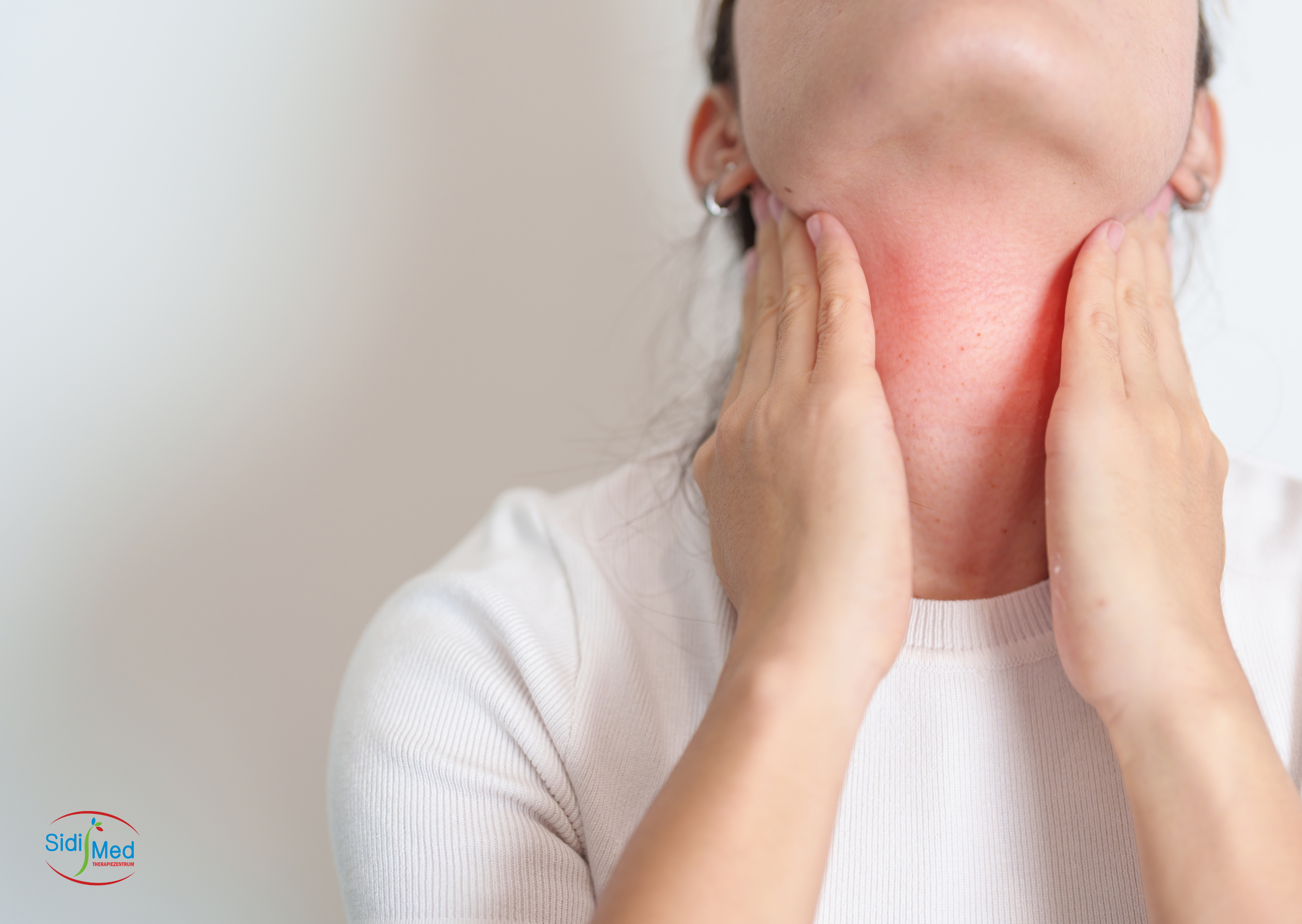 Funktionelle Stimmstörung - Frau hält sich am Hals fest